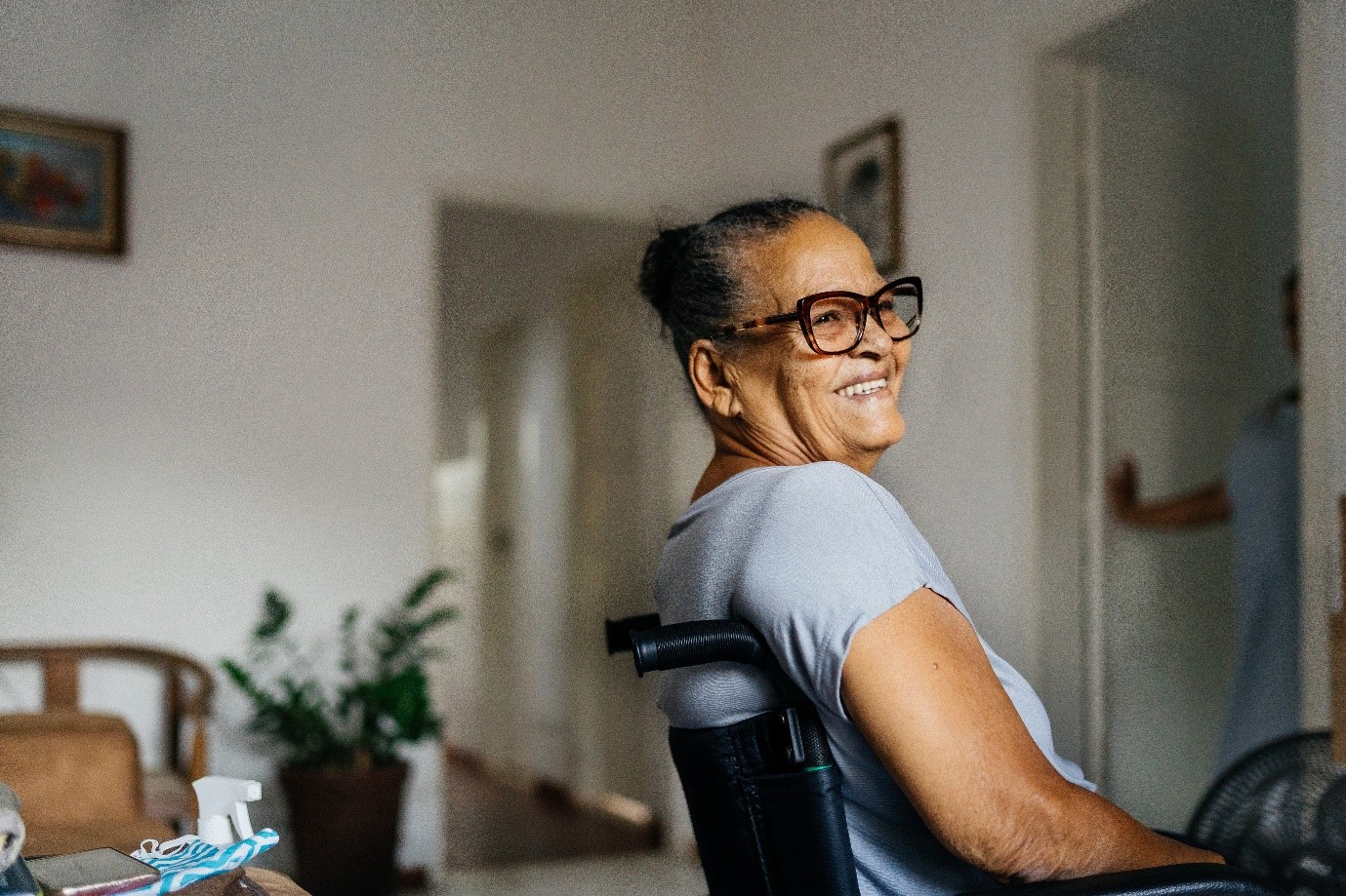 Older black person sitting in a wheelchair and smiling